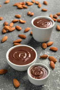 Gri grunge arka planda bademli lezzetli eritilmiş çikolatalar