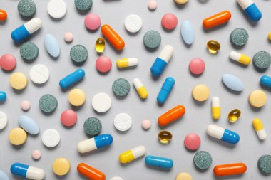 Gri arka planda farklı renkli haplar.