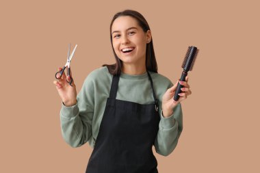 Makasla kadın kuaför ve kahverengi arka planda fırça.