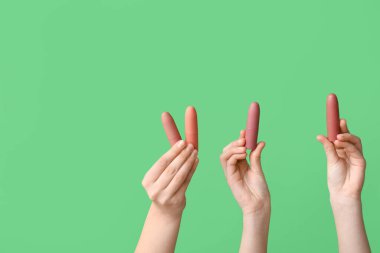 Yeşil arka planda ruj izi olan kadın eller.