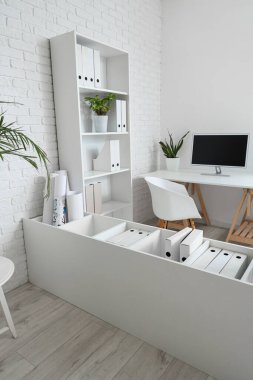 İçi masalar, raf üniteleri ve bitkilerle dolu.