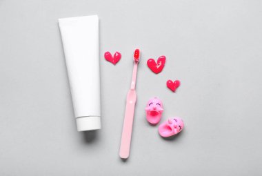 Gri arkaplanda diş macunu ve diş fırçası tüpü