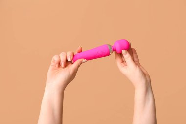 Renkli arka planda vibratörü olan kadın elleri, yakın plan