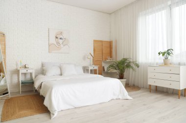 Rahat yatağında yumuşak yastıklar olan modern yatak odasının içi.