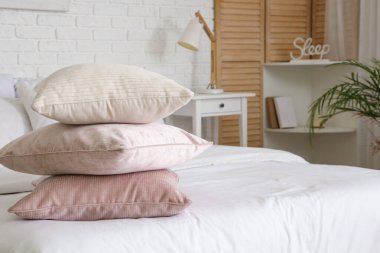 Yatak odasındaki rahat yatakta yumuşak yastıklar, yakın çekim.