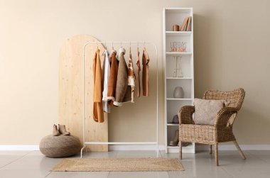 Modern odanın iç kısımlarında şık kadın kıyafetleriyle dolu raflar.