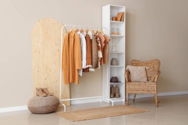 Modern odanın iç kısımlarında şık kadın kıyafetleriyle dolu raflar.