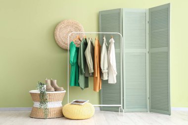 Kadın giysileri ve katlanan perdesi olan modern odanın şık bir iç mekanı.