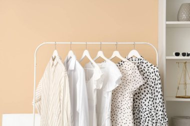 Renkli duvarın yanında asılı şık kadın kıyafetleri.