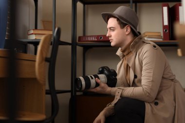 Ofisinde fotoğraf makinesi olan bir erkek casus.