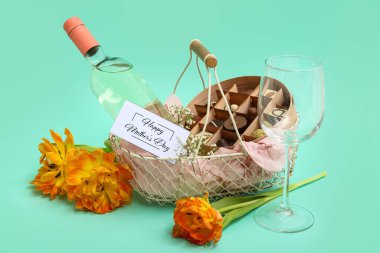 Bir sepet dolusu şeker, bir şişe şarap ve anneler günü kutlaması için lale çiçekleri.