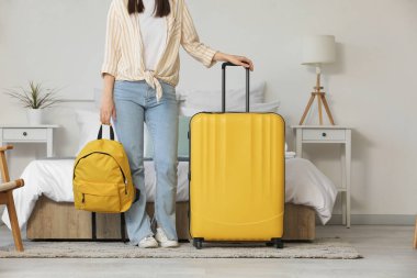 Bavullu ve sırt çantalı kadın otel odasında.