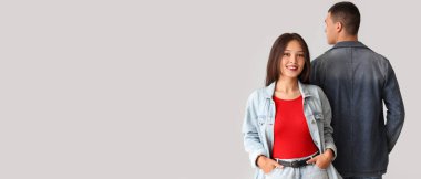 Gri arkaplanda kot ceketli şık genç bir çift ve metin için yer var.