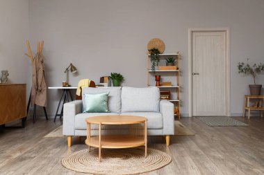 Gri kanepesi ve kahve masası olan modern oturma odasının içinde.
