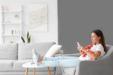 İzin gününde cep telefonu kullanan genç bir kadın.