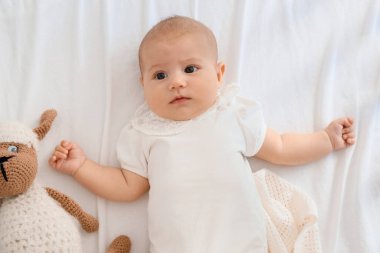 Evinde beşiğinde oyuncak olan tatlı bir bebek.