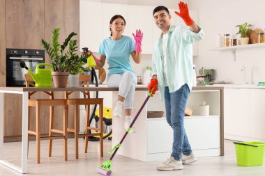 Mutfakta temizlik yapan mutlu genç çift.