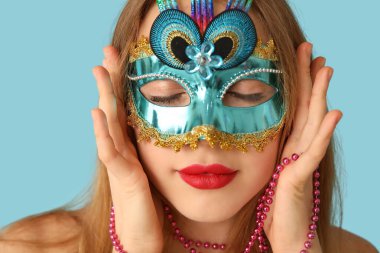Mavi arka planda karnaval maskeli güzel bir kadın.