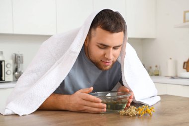 Genç adam mutfakta buhar solumuş.