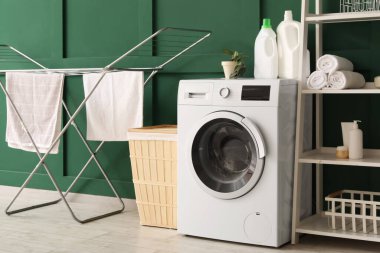 Çamaşır sepeti, kurutma makinesi ve çamaşır makinesi olan odanın içi.