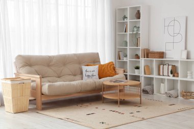 Posteri, raf ünitesi ve kanepesi olan şık bir oturma odası.