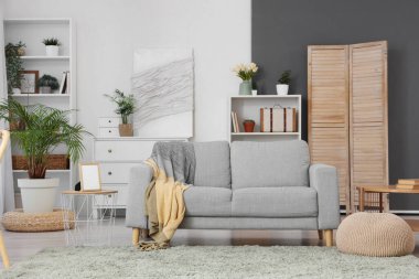 Kanepesi ve duvarında resim olan şık bir oturma odası.