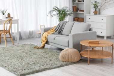 Şık oturma odasının içinde kanepe, puf ve masa var.