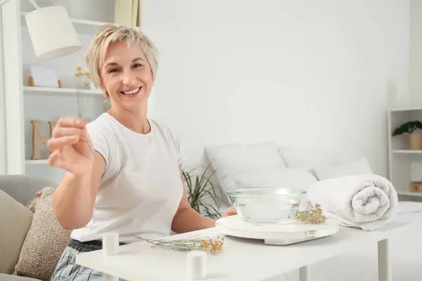 stock image Mature woman preparing steam inhalation with herbs in bedroom