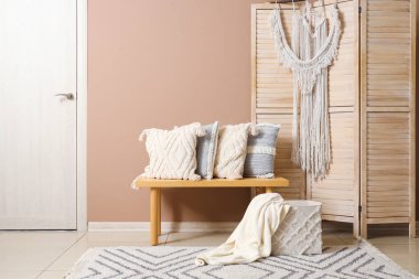 Odanın içi ahşap bankta şık yastıklarla dolu.