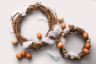 Gri arka planda yumurta ve tüylü güzel Paskalya çelenkleri