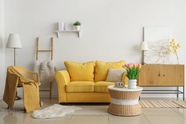 Uluslararası Kadınlar Günü için laleler ve kanepelerle aydınlık oturma odasının içinde.