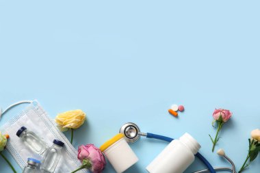 Mavi arka planda Uluslararası Hemşireler Günü için haplar, ampuller ve güllerle steteskop