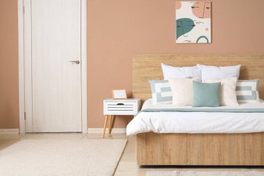 Yatak odasının içinde yatak ve kapısında yastıklar var.