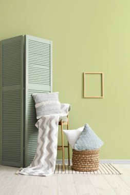 Oturma odasının içinde yastıklar, dışkılar ve katlanan perdeler.