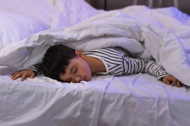 Geceleri yatak odasında uyuyan tatlı küçük çocuk.