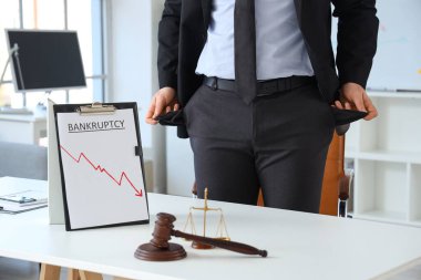 İflas etmiş işadamı. Masada boş cepleri var. Yakın plan.