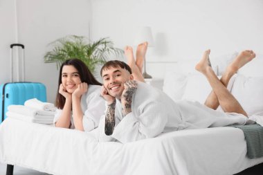 Bir çift turist otel odasında yatakta yatıyor.