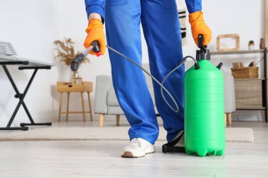 Erkek işçi odayı dezenfekte ediyor, yakın plan.