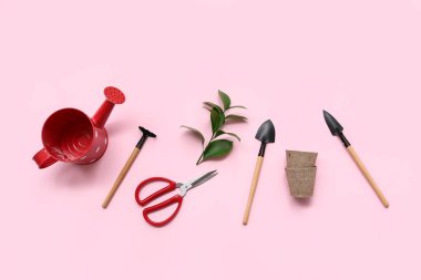 Pembe arka planda bahçe aletleri. Üst görünüm