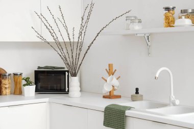 Mutfağın iç tarafında söğüt dalları olan bir vazo.