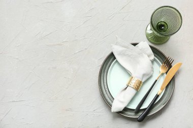 Gri arkaplanda altın çatal bıçak seti olan güzel bir masa.