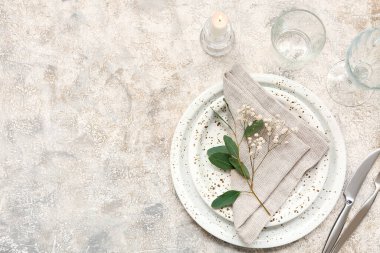 Gri arkaplanda yapraklar ve çigila çiçekleri olan güzel bir masa.