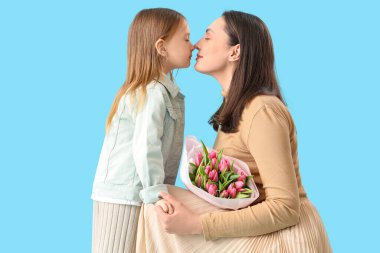 Laleli genç bir kadın ve küçük kızı mavi arka planda burunlarına dokunuyor. Anneler Günü kutlaması