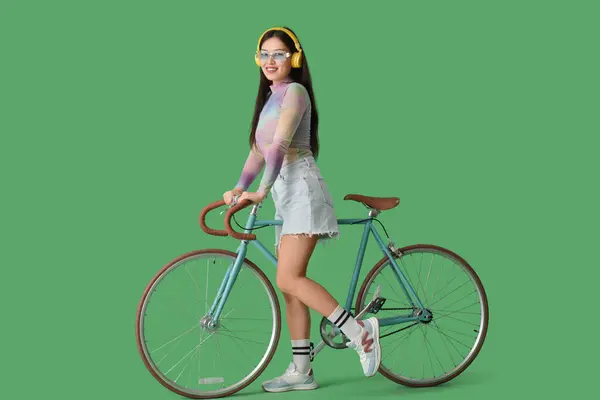 Mulher Asiática Bonita Fones Ouvido Com Bicicleta Fundo Verde Fotos De Bancos De Imagens