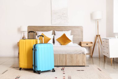 Yatağın yanında bavulları olan modern bir otel odası.