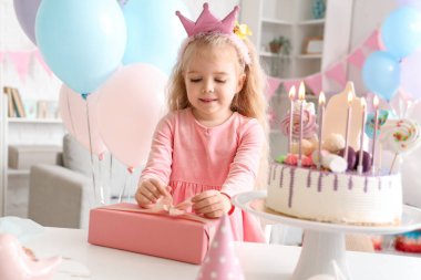 Doğumgününü evde kutlayan sevimli küçük bir kız.