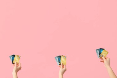 Pembe arka planda kredi kartı olan kadınlar