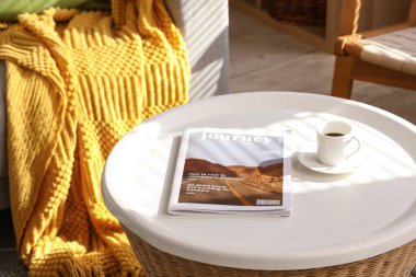 Oturma odasında kahve ve dergi dolu bir masa, yakın plan.