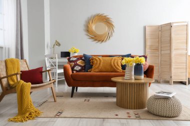 Süslü oturma odasındaki sehpanın üzerinde narsis çiçekleri olan vazolar.