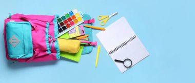 Stil okul çantası ve açık mavi arkaplan üzerinde farklı kırtasiye malzemesi metin ve üst görünüm için alan